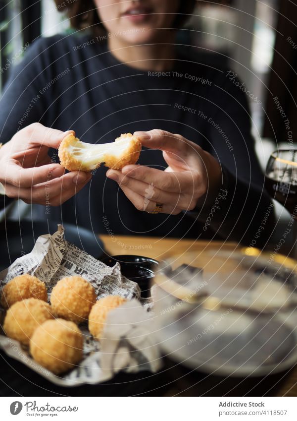 Woman eating cheese balls in cafe woman fried snack delicious fast food crispy tasty fill mozzarella stretch meal female positive cuisine table nutrition dish
