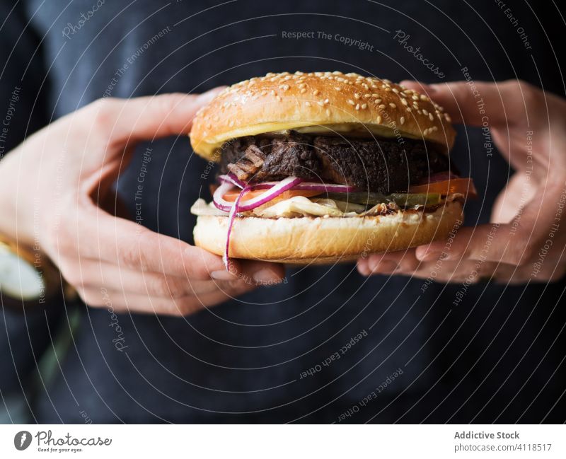 Person holding hamburger in hands fast food snack junk food meat beef lunch dinner unhealthy meal person cuisine bun dish classic sesame bread appetizing salad