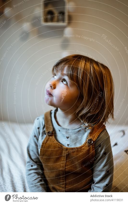 Portrait of an adorable little girl home cozy rest cute casual calm portrait outfit kid room childhood relax innocent domestic blond emotionless unemotional