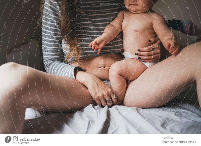 Real image of a woman and her baby at postpartum recovery childbirth motherhood real body positive people mom home quarantine belly belly button pregnancy