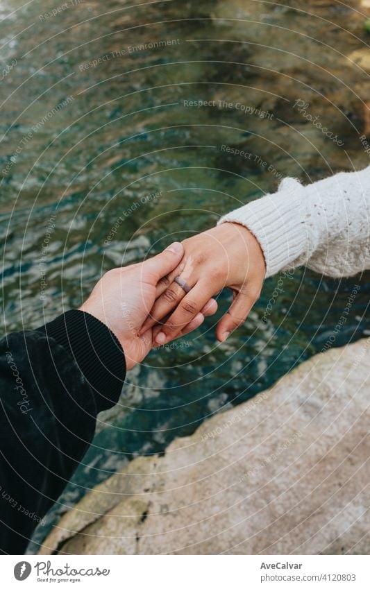 One hand grabbing another hand with a river as the background using a rubber ring love concept woman female vacation girl summer beach sea young relax water