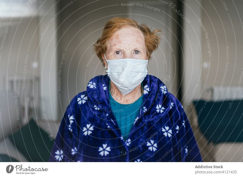 Aged woman in medical mask standing and looking at camera hospital infection disease virus protect room risk group clinic senior aged self isolation quarantine
