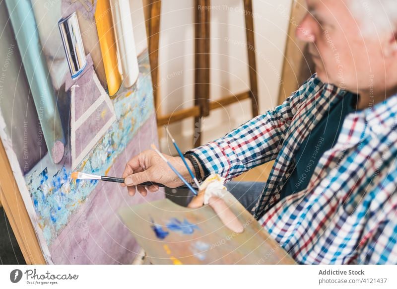 Aged man painting picture with brush artist aged paintbrush home inspiration draw concentrate palette oil easel paper studio hobby workshop gallery equipment