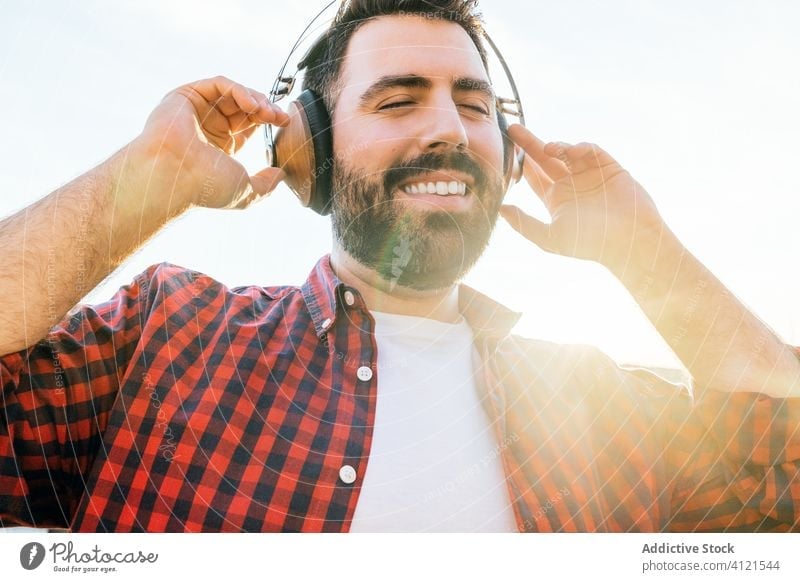 Young man listening to music at home young lifestyle outside guy phone technology mobile earphones outdoor male cellphone adult casual smile smart people