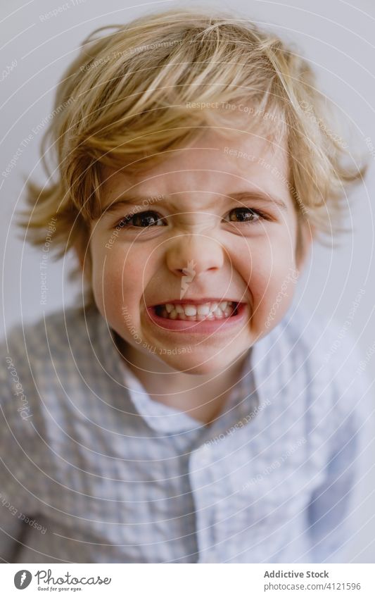 Delighted boy smiling and pointing at camera smile delight little kid adorable child content cheerful optimist cute childhood positive casual face expression