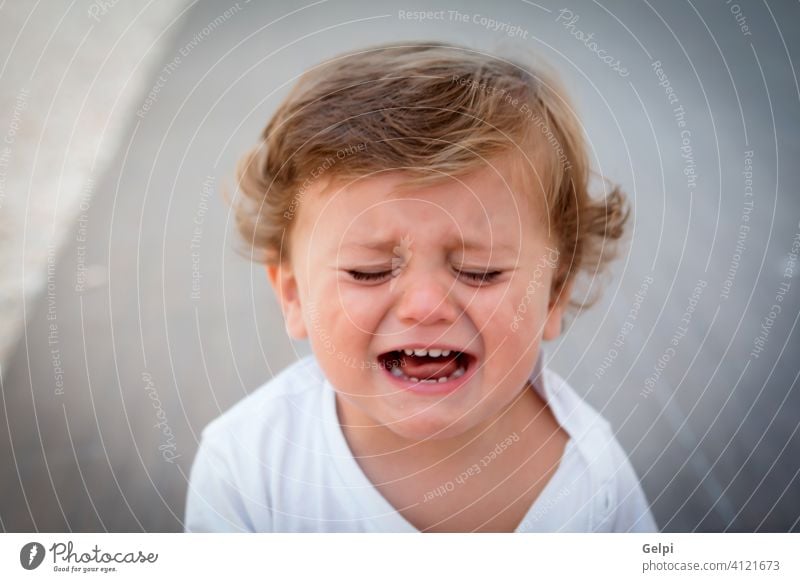 Funny baby one year crying cute child white sad expression cool summer outdoor toddler boy unhappy caucasian little kid lifestyle beautiful portrait background