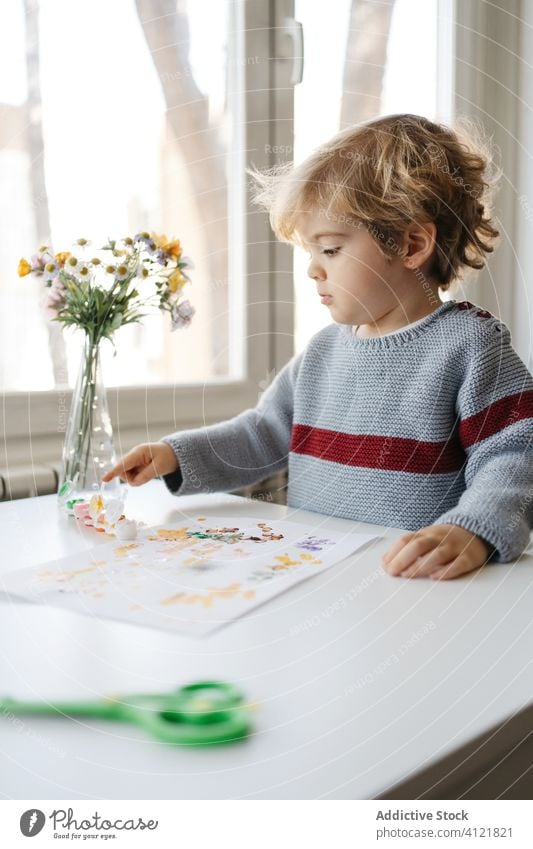 Blond child using gouache for finger painting at home boy draw creative kindergarten stick drawing paper little cute adorable childhood preschool blond hobby