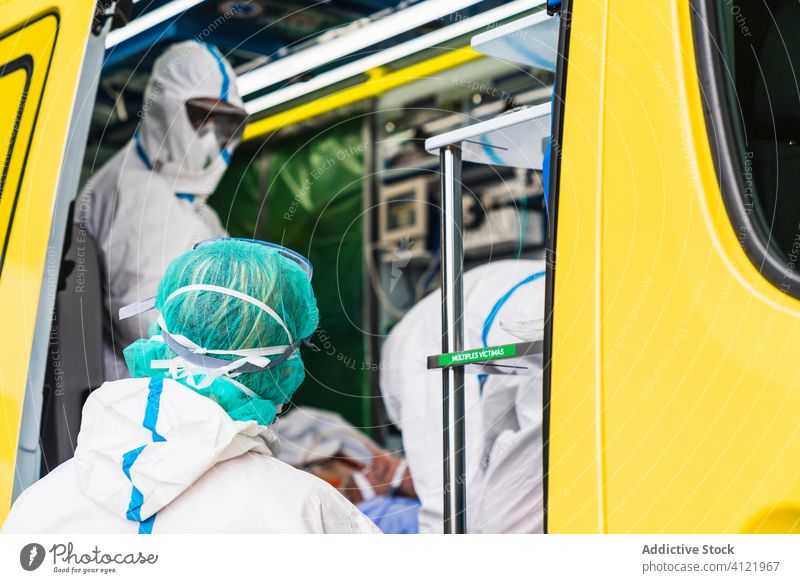 Doctors in protective suit standing in ambulance car doctor door equipment patient virus infection examine uniform inspect hospital service vehicle safety