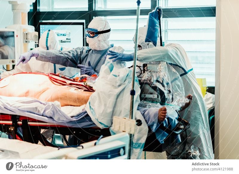 Doctors in protective uniform working in operating room in hospital doctor clinic viral patient care infection equipment treat specialist mask health care