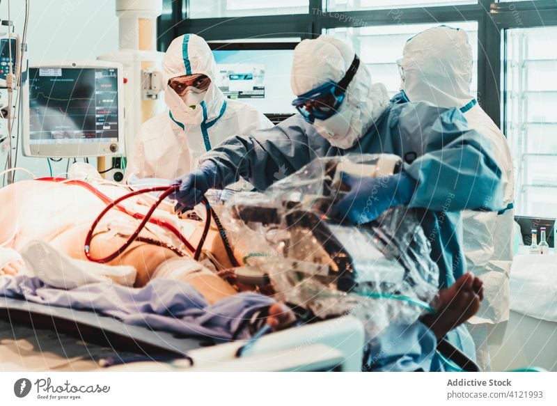 Doctors in protective uniform working in operating room in hospital doctor clinic viral patient care infection equipment treat specialist mask health care