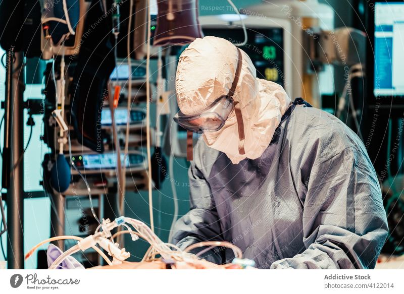 Doctor in protective uniform working in operating room in hospital doctor clinic viral patient care infection equipment treat specialist mask health care