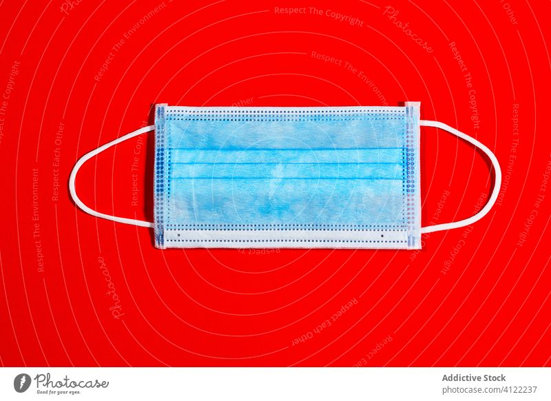 blue single-use mask for virus protection on red background coronavirus epidemic health quarantine infection hospital pandemic medical disease china laboratory