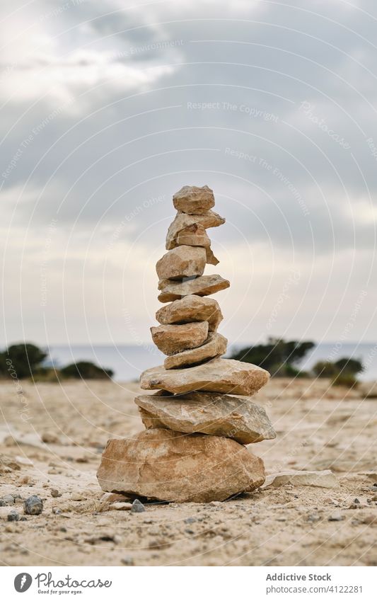 Stones stacked on each other on sandy ground in Ibiza beach stone seashore empty zen calm harmony freedom peace landscape weather sky ocean day nature coast