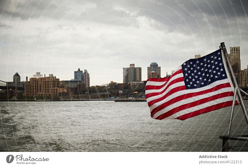 American flag on floating boat national usa vessel water city coast sky cloudy american united states new york nyc patriot wave building wind cityscape travel