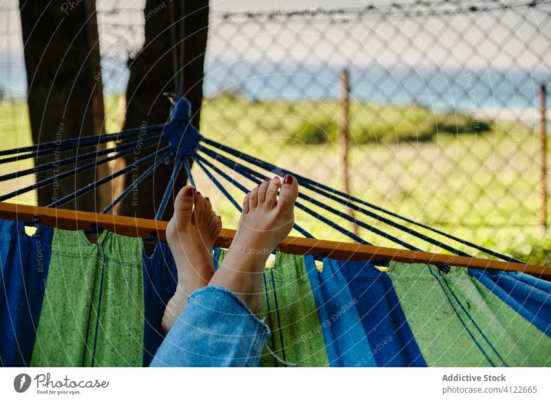 Woman lying in hammock in courtyard woman relax enjoy summer weekend barefoot sunny female tropical vacation calm landscape scenery exotic holiday legs crossed