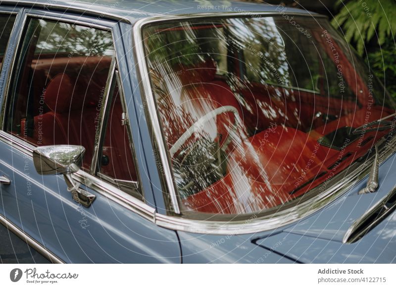 Shiny retro car in green park shiny vintage parked tropical interior windshield antique bali indonesia tree reflection greenery plant exotic summer auto