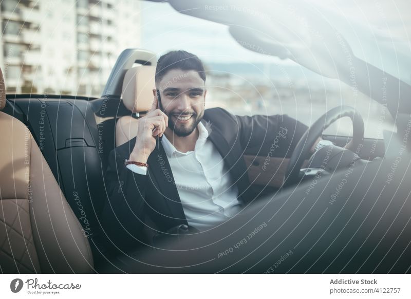 Attractive businessman with convertible car, calling by mobile automobile person people young driver traffic vehicle fashion phone talking success cruise