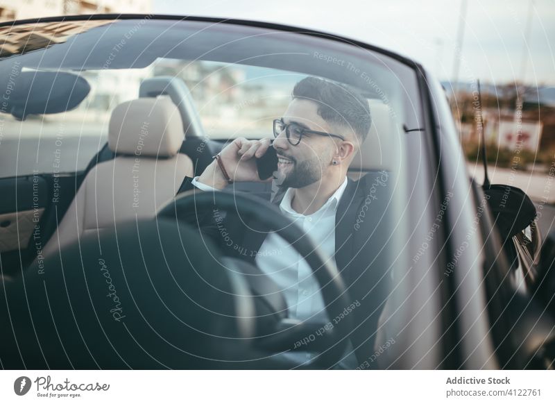 Attractive businessman with convertible car using her mobile automobile person people young driver traffic vehicle screen fashion phone call talking success