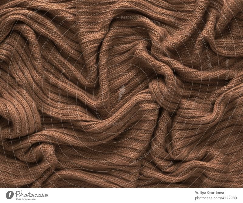 Brown crumpled knitted scarf or sweater texture, top view. Texture background of warm crocheted clothing textile. Knitwear fabric. knitting copy space border
