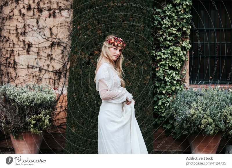 Young bride standing near old estate woman house yard bush vine flora elegant wedding female young dress wreath aged potted flower style celebrate serene decor