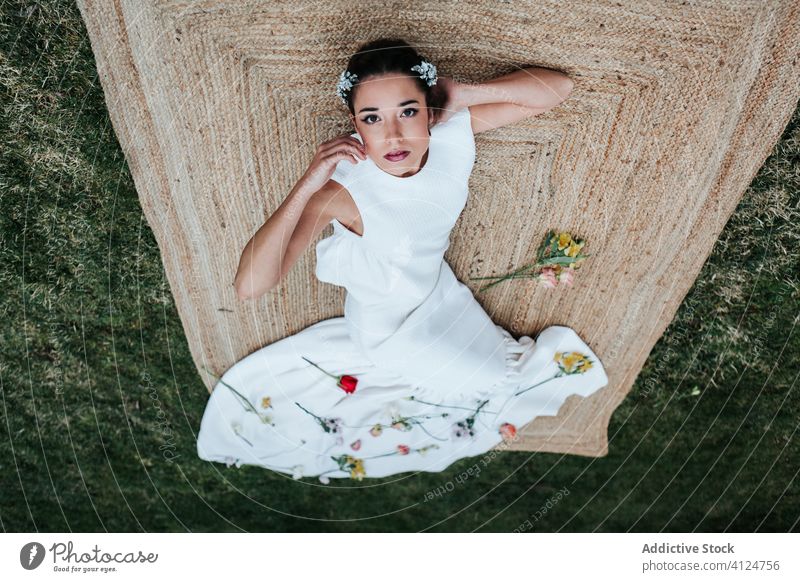 Young bride lying on lawn in park woman wedding concept rag pillow dress flower elegant green garden grass young plant tranquil rest serene calm fresh summer