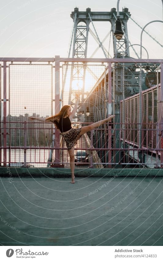 Woman dancing barefoot on bridge in city woman dance balance tiptoe grace dancer industrial practice choreography female slim flexible slender elegant charming