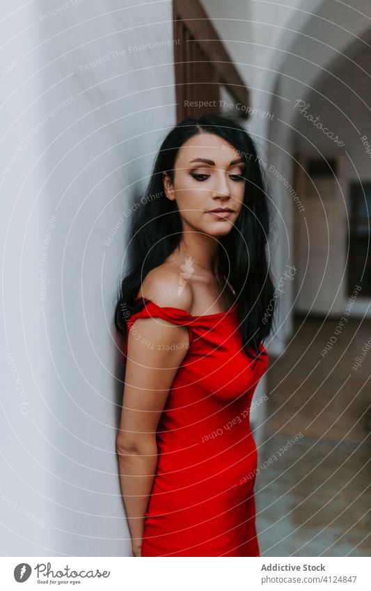 Young woman in red dress near white building style wall arms crossed elegant attractive young model female fashion slim beautiful pretty trendy gorgeous glamour