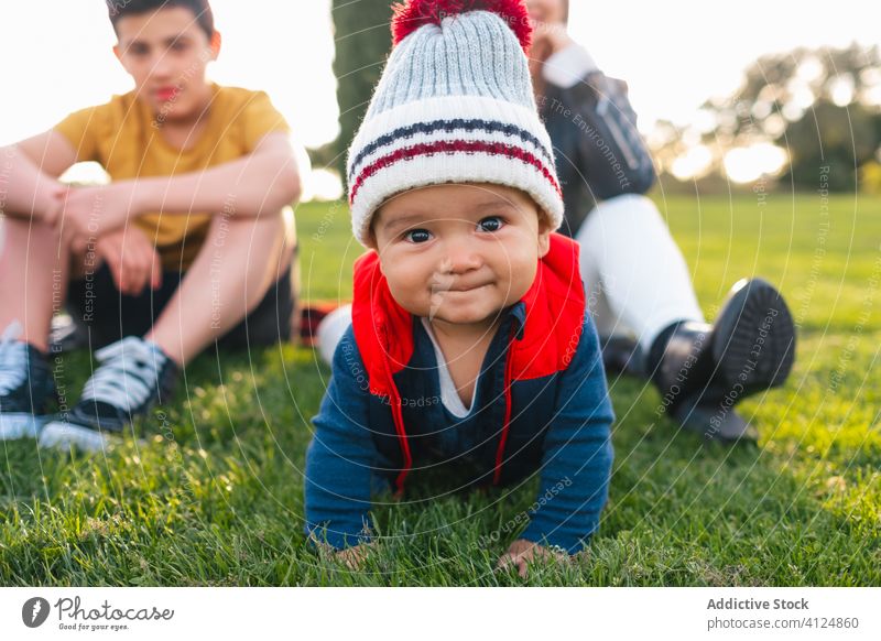 Happy little kid crawling on green grass happy family toddler meadow smile nature cute ethnic countryside child joy baby cheerful childhood parent rest together