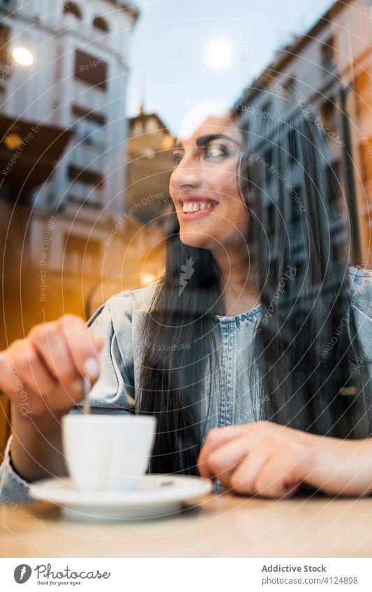 Cheerful young woman sitting in cafe cheerful trendy style enjoy coffee window female counter drink cozy cafeteria relax happy lifestyle city rest smile break