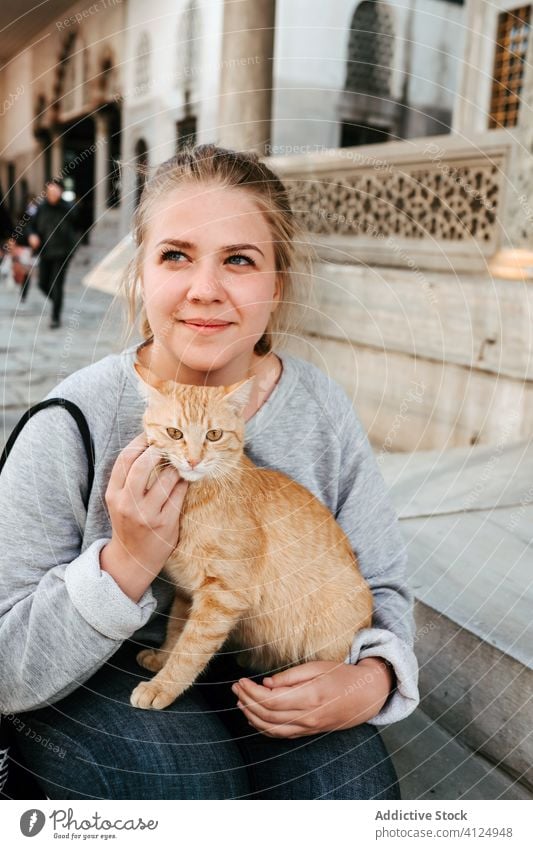 Smiling woman with cat on street cheerful tourist local stroke city walk cute travel joy kind istanbul turkey happy casual lifestyle urban female outdoors
