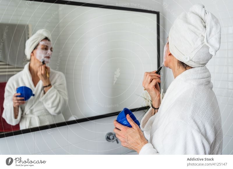 Woman applying cosmetic mask on face facial woman moisture brush skin care hydrate cosmetology female bathroom liquid natural hygiene beauty wellness procedure