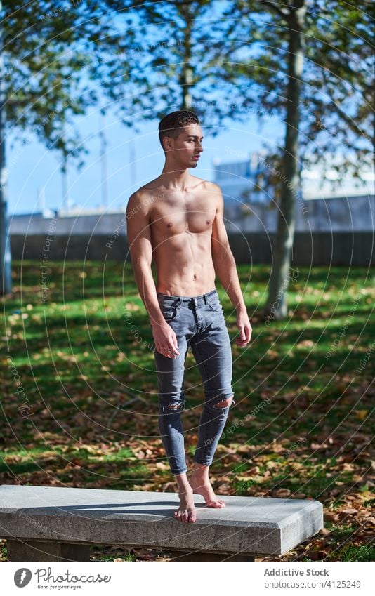 Shirtless fit man standing in park shirtless confident dancer grace athlete abs barefoot naked torso jeans autumn healthy motivation sportsman sunny serious