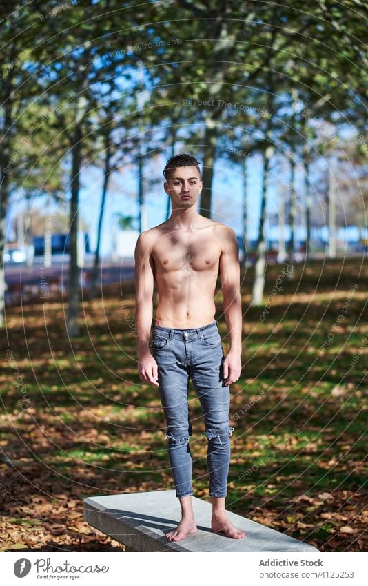 Shirtless fit man standing in park shirtless confident dancer grace athlete abs barefoot naked torso jeans autumn healthy motivation sportsman sunny serious
