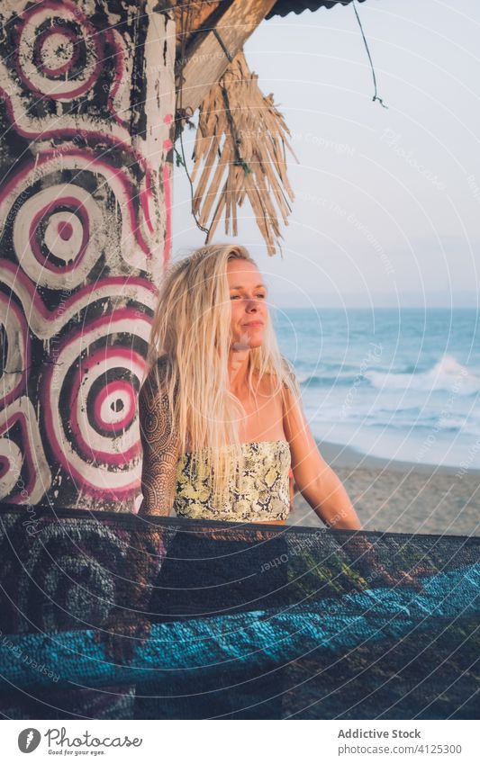 Female standing near wall with colorful graffiti on the beach woman freedom happy summer street admire peaceful harmony outdoors blonde shore beautiful art