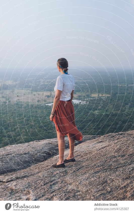 Anonymous woman standing in a stone in mountainous area hill travel valley summer carefree freedom holiday female sigiriya sri lanka casual outfit wear forest