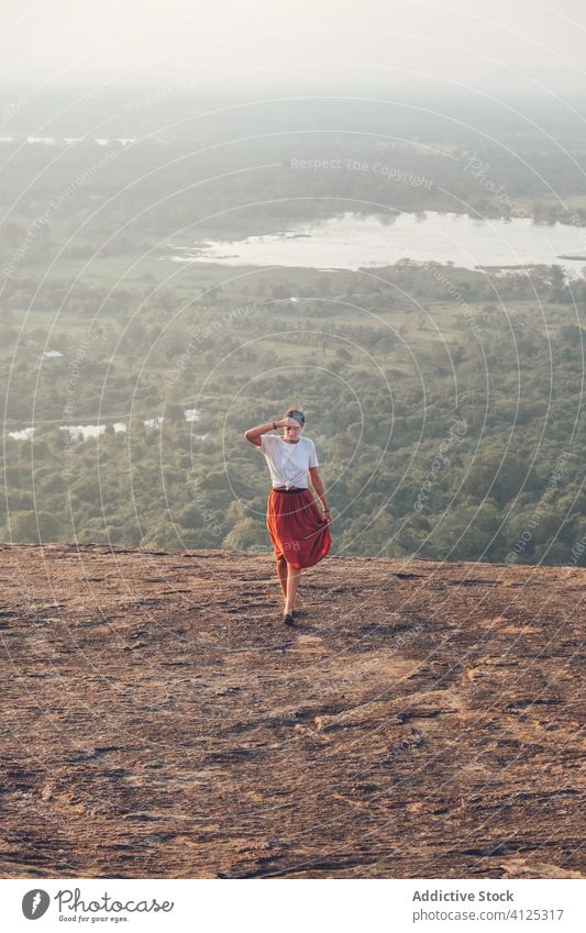 Carefree woman walking uphill in mountainous area travel valley summer carefree freedom holiday female sigiriya sri lanka casual outfit wear forest landscape