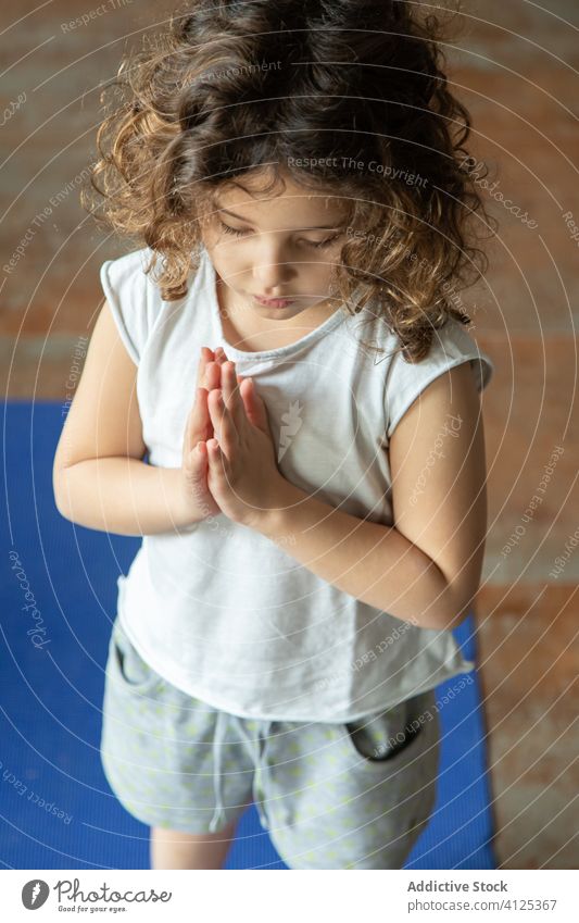 Little child doing namaste gesture practicing yoga kid practice home girl prayer pose calm tranquil mat little healthy energy female meditate concentrate zen