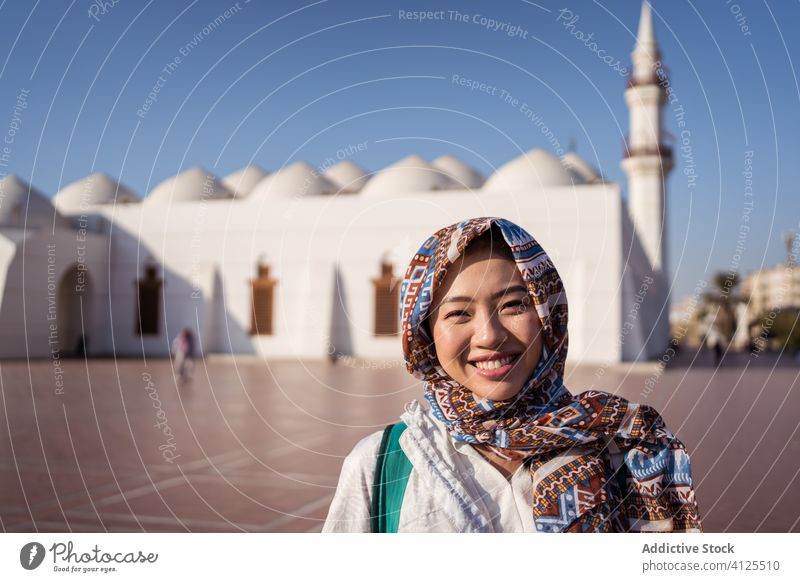 Ethnic woman standing against Islam mosque happy young street smile tradition religion islam positive ethnic asian female sightseeing saudi arabia jeddah city