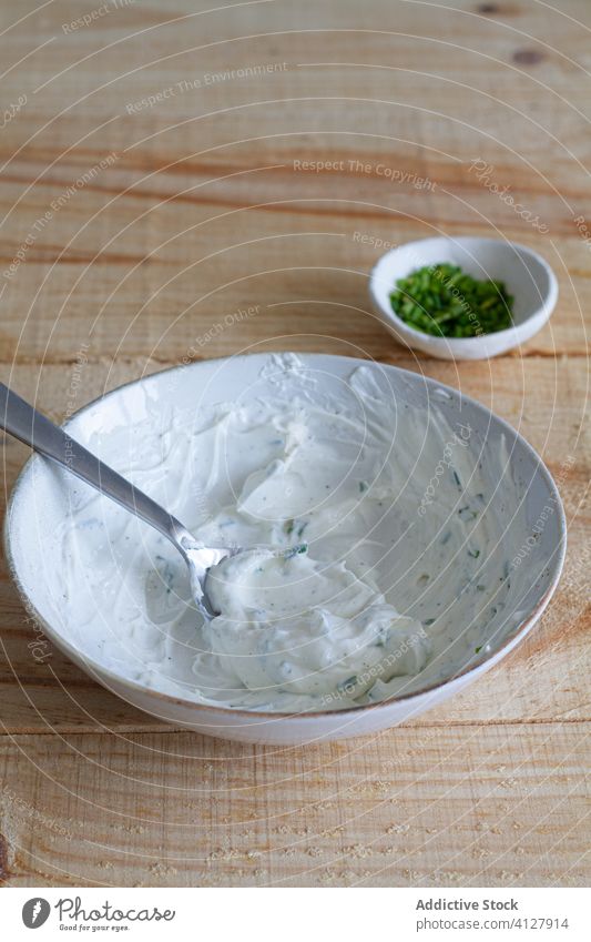 Bowl with sour cream sauce with herbs on table bowl tasty onion green mix delicious homemade food gourmet yummy appetizing culinary cookery greenery spoon