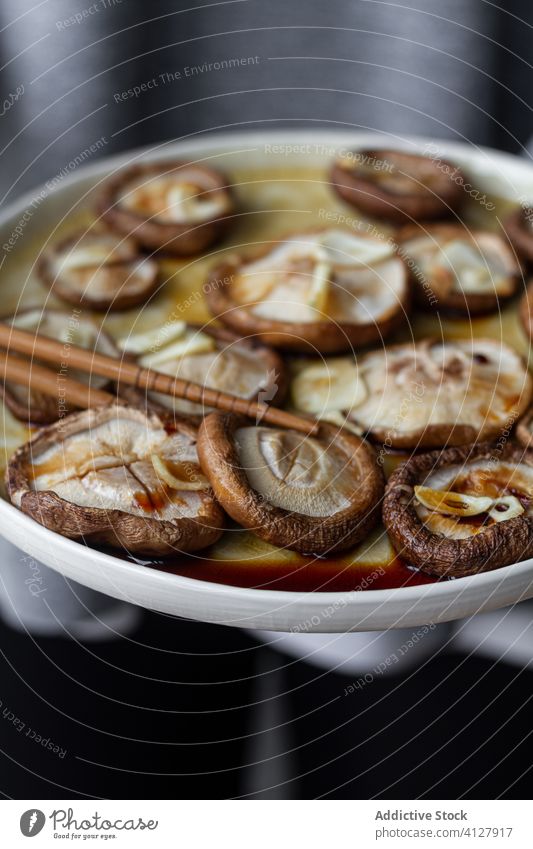 Tasty baked mushrooms with garlic poured with soy sauce food meal shiitake plate chopstick dinner gastronomy nutrition cuisine cap asian food gourmet culinary