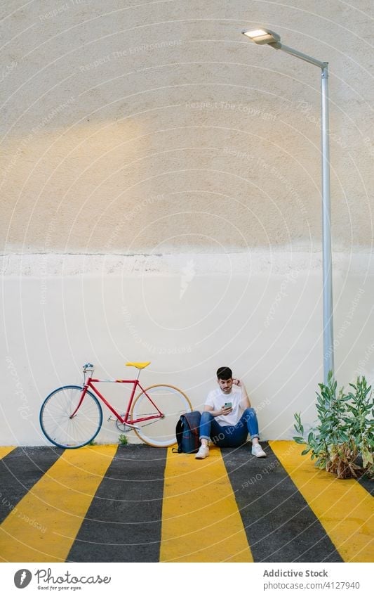 Man sitting on the floor with a bike bicycle fixie urban wheel fixed sport transportation gear lifestyle wall street hipster ride pedal man biking chain action