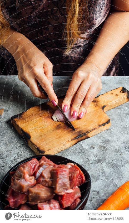 Woman peeling onion with knife in kitchen housewife vegetable apron dice cutting board female raw fresh chopping board bowl meat beef food uncooked lady prepare