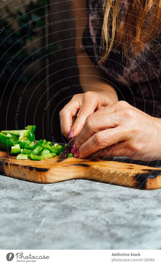Crop female cook cutting pepper in kitchen cutting board woman chop chopping board housewife knife prepare fresh table food uncooked cuisine culinary dinner