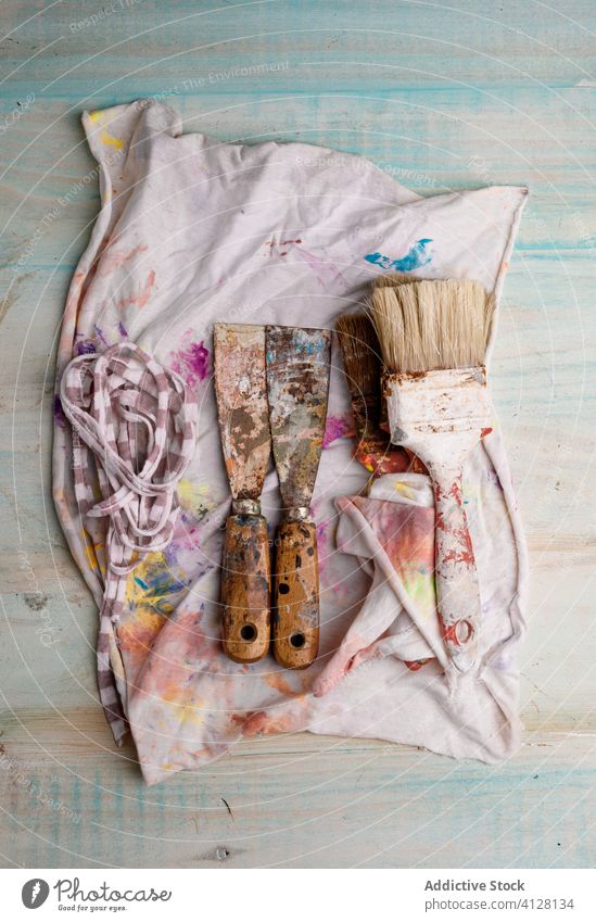Paintbrushes and ink spatulas on painted cloth paintbrush creative hobby messy scraper inspiration color artwork colorful imagination table wooden bright vivid