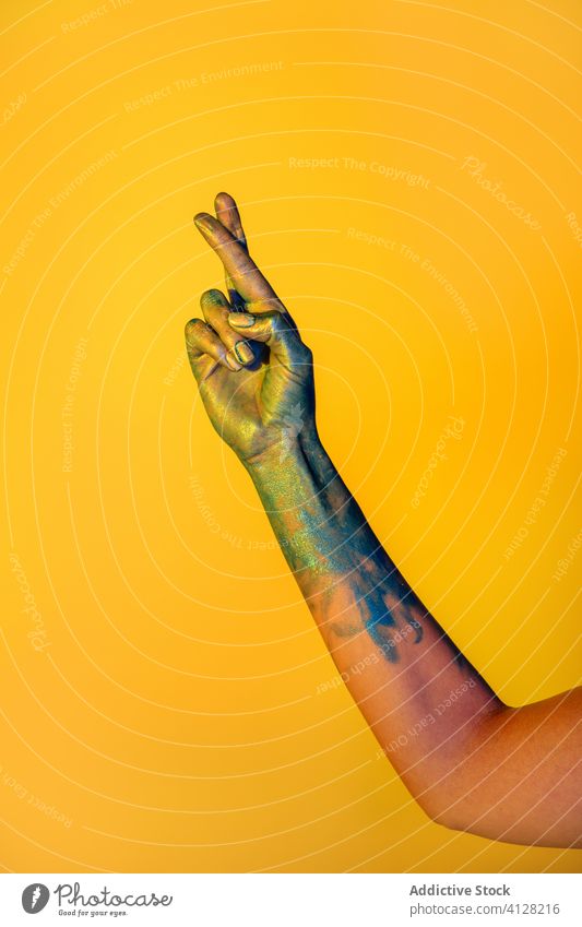 Crop woman snapping fingers in studio paint gesture show sign creative gesticulate art female concept metallic symbol colorful abstract dye glitter multicolored