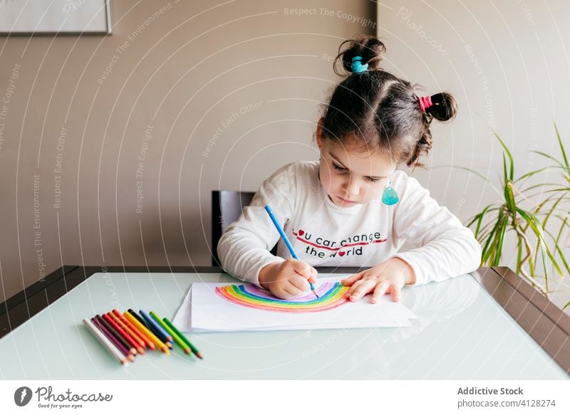 Girl drawing picture on paper at table at home girl rainbow pencil creative optimist positive colorful bright inspiration kid art child paint imagination