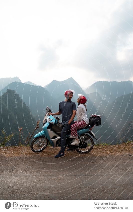 Delighted couple on motorcycle in mountains traveler road fog range delight highland roadside vietnam asia tourist content transport vacation parked enjoy
