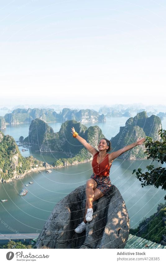Cheerful female tourist on high rock above bay halong bay viewpoint woman travel enjoy summer holiday ha long bay vietnam asia spectacular breathtaking scenery