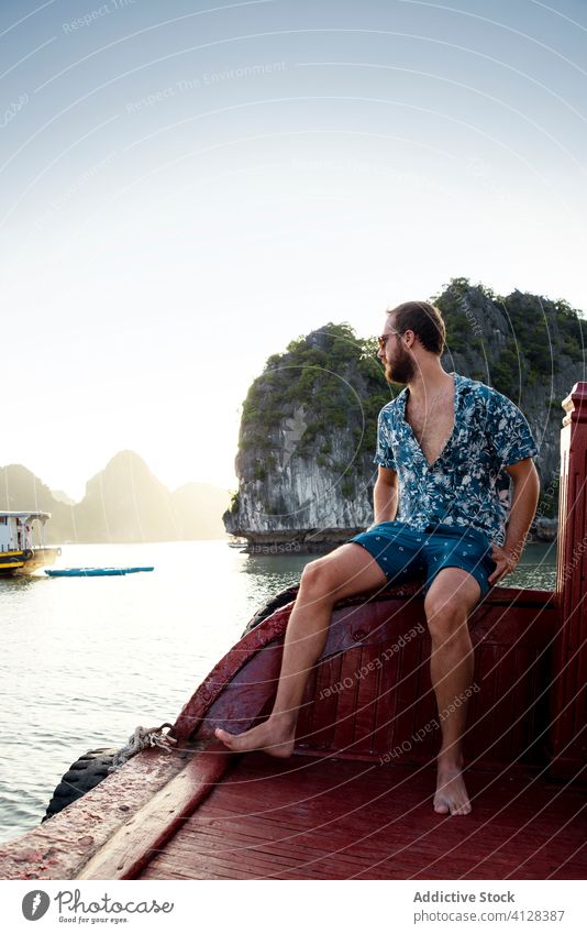 Man relaxing on pier in Halong bay travel man mountain admire halong bay rest quay male ha long bay vietnam asia tourism tourist traveler casual wear summer
