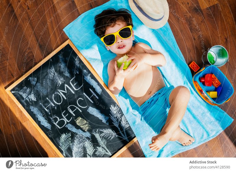 Happy little boy in sunglasses having beach at home dreaming of summer self isolation fun happy social distancing quarantine cheerful yellow blue playful